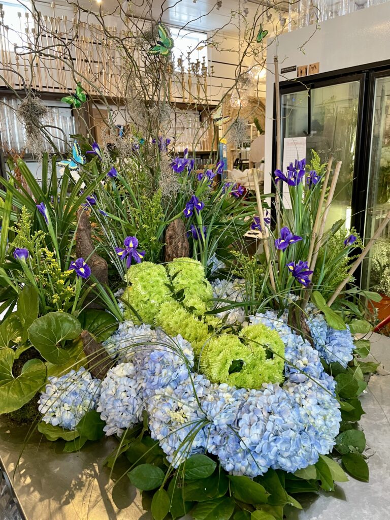 Outdoor garden with multiple flowers, including Irises, representing New Orleans florist, TPG - The Plant Gallery